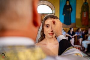 Close-up wedding photography session with vibrant yellow church walls in the background.