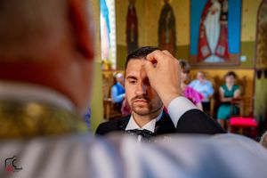 Wedding photography scene in a church with distinctive yellow walls and religious artwork.