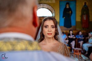 Wedding portrait session with bright yellow walls and religious artwork in the background.