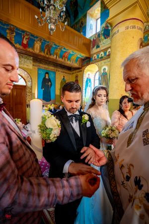 Traditional Orthodox wedding ceremony with priests performing rituals in a beautifully decorated church.