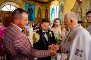 Orthodox wedding ceremony with clergy performing blessing rituals in decorated church interior.