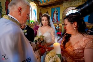 Candlelit Orthodox wedding ceremony with religious icons adorning the church walls.