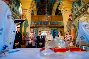 Orthodox church interior with golden columns and religious murals during a wedding ceremony.