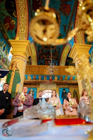 Wedding ceremony captured through crystal decorations with bokeh effects in an ornate church.