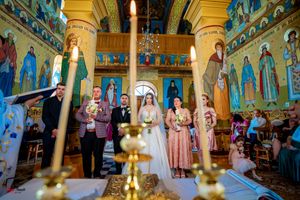 Panoramic view of an Orthodox church interior with golden chandeliers and painted religious icons.