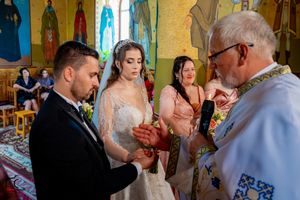 Traditional Orthodox wedding ceremony with exchange of rings in an iconographic church setting.