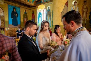 Wedding ceremony guests gathered in an ornate church with yellow walls and blue accents.
