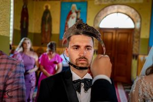 Wedding party gathered in a traditional church with yellow walls and architectural details.