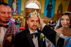 Orthodox wedding celebration with ceremonial crowns and traditional religious elements.