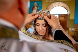 Close-up shot of wedding ceremony with ornate crown and veil details.