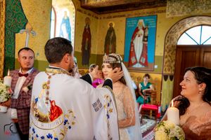 Wedding celebration in an Orthodox church with religious murals and traditional ceremonial elements.
