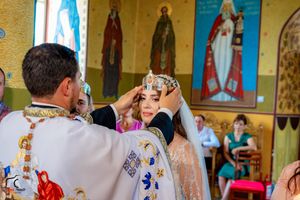 Orthodox wedding service with religious icons and murals visible on the church walls.