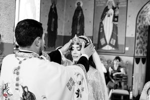 Black and white photo of Orthodox wedding ceremony showing traditional religious rituals.