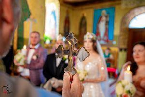 Wedding ceremony in progress at an Orthodox church with traditional religious iconography.