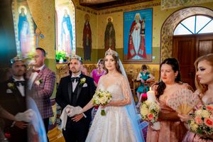 Wedding ceremony in an ornate church with yellow walls and decorative blue accents.
