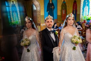 Traditional wedding ceremony taking place in a beautifully decorated church with golden walls.