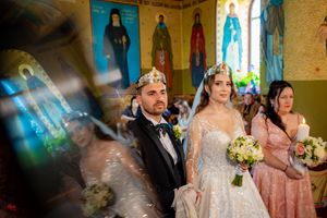 Wedding celebration in a historic church with distinctive yellow walls and religious artwork.