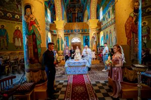 Panoramic view of a church wedding venue with colorful religious artwork and golden walls.