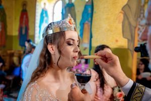 Traditional Orthodox wedding ceremony showing ritual wine drinking with ornate crowns.