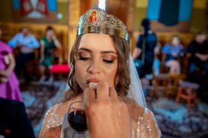 Bride wearing an ornate crystal headpiece during a traditional Orthodox church wedding ceremony.