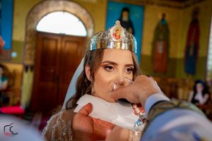 Traditional Orthodox wedding ceremony taking place in a beautifully decorated church with blue and gold details.