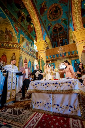 Orthodox church interior with decorated altar table and stunning turquoise walls adorned with religious artwork.