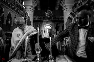 Black and white image of a church ceremony with dramatic lighting and architectural details.