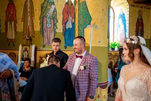 Religious ceremony in a Byzantine-style church interior with decorated walls and golden pillars.