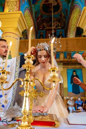 Close-up of wedding ceremony rituals with golden candelabras and religious texts.