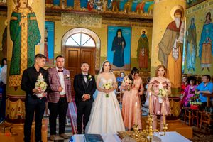 Orthodox wedding ceremony in an ornate church with golden walls and religious icons.
