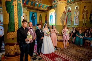 Traditional Orthodox wedding ceremony taking place in a richly decorated church interior.