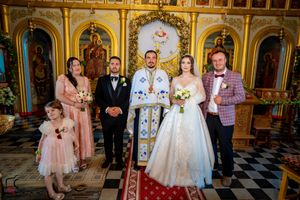 Wedding celebration in an Orthodox church featuring elaborate iconography and gold detailing.