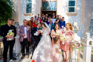 Wedding celebration with bridesmaids in pink dresses outside a traditional church building.