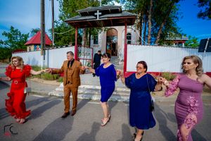 Celebratory dance line moves in sync during outdoor wedding festivities.