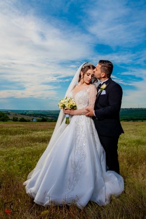 Romantic wedding portraits in tall grass with beautiful natural lighting and mountain backdrop.