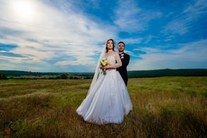 Elegant wedding photography featuring a white gown against natural grassland scenery.