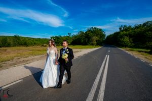 Wedding photographs being taken on an empty rural road surrounded by nature.