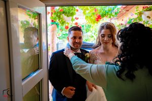 Candid moments captured during a wedding celebration under a floral-decorated pergola.