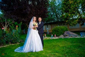 Wedding photography session in outdoor garden with dramatic lighting and flowing veil.