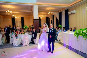 Spacious wedding venue with elegant decor and purple lighting effects.