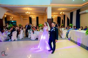 Wedding reception ballroom with dance floor and ambient purple lighting design.