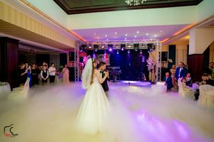 A dreamy first dance scene with fog effects and purple lighting in a luxurious wedding reception venue.