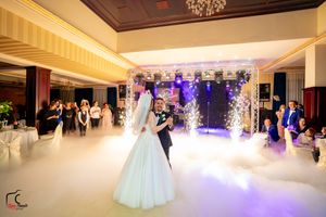 Romantic wedding dance scene with purple-lit archway and fog effects in an elegant ballroom setting.