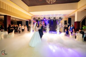 A romantic first dance at a wedding reception with dramatic lighting and fog effects on the dance floor.