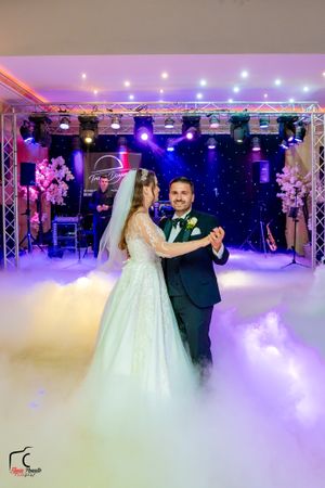 Romantic dance moment captured with dramatic purple lighting and low-lying fog effects.
