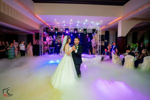 Elegant wedding dance in a beautifully lit ballroom with fog effects and crystal chandeliers.