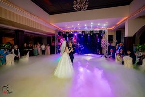 Wedding reception featuring dramatic purple lighting and fog effects during a romantic dance.