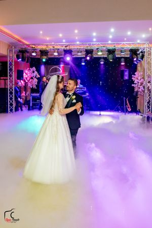 Intimate dance moment captured with starlit backdrop and dreamy fog effects at wedding reception.