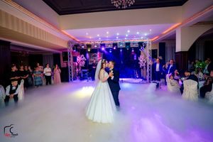 Wedding reception space with dramatic lighting design and fog-filled dance floor.