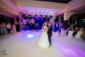 Wedding reception venue featuring dramatic lighting and atmospheric fog effects on dance floor.